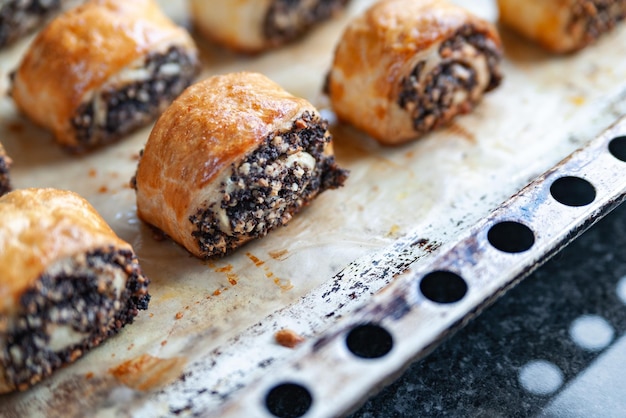 Crispy freshly baked cookies with poppy seeds on a baking tray Closeup hot crunchy nut rolls