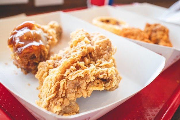 Crispy fried chicken junk food in the paper box of a franchise cafe.