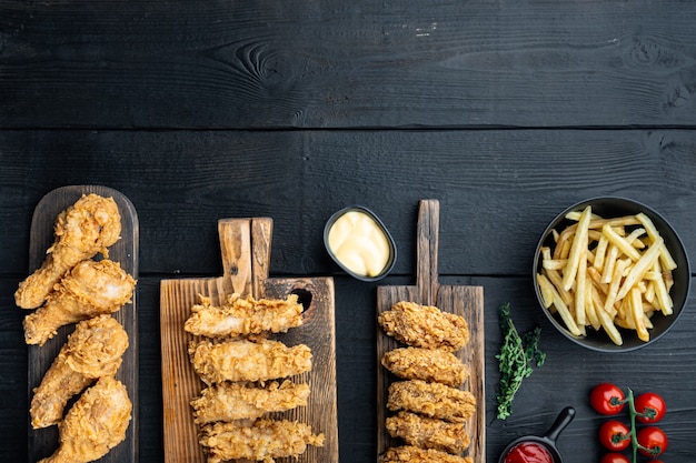 Crispy fried chicken parts on black wooden table