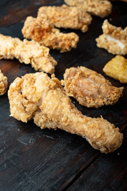 Crispy fried chicken parts on old dark wooden table