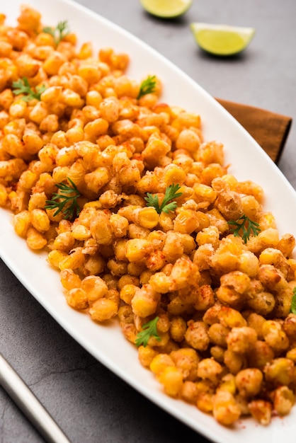 Crispy fried corn is a chatpata starter snack from india, served in a bowl, selective focus