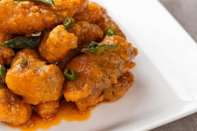 Crispy fried dori fish coated with salted egg plated on a white plate