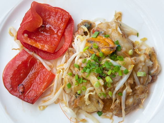 Crispy Fried Mussel Pancake with Grilled Sweet Peppers Served on White Plate. Thai Food.