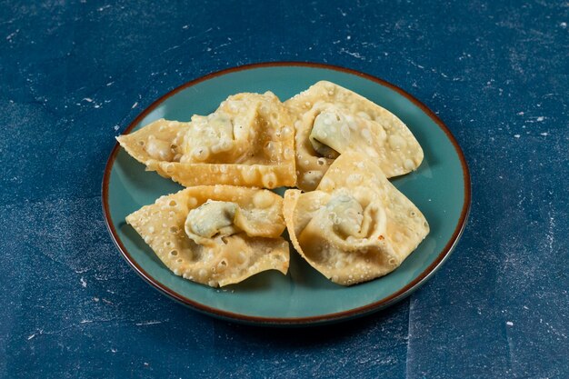 Crispy fried wonthon dim sum wraps with tomato sauce served in a dish isolaed on table top view