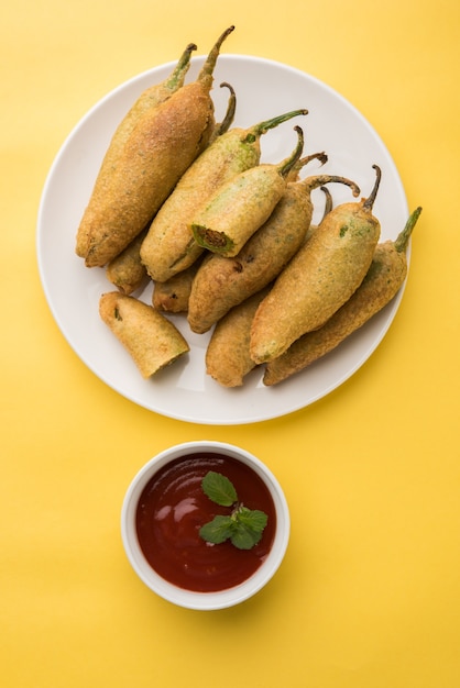 Crispy Green Chilli Pakora or Mirchi Bajji, served with tomato ketchup. Its a popular tea time snack from India especially in Monsoon. Selective focus