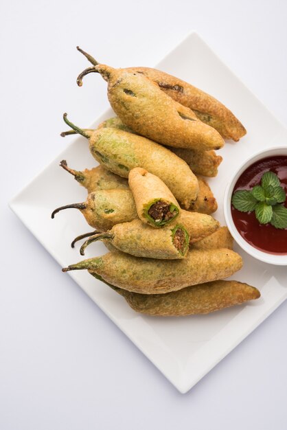 Crispy Green Chilli Pakora or Mirchi Bajji, served with tomato ketchup. Its a popular tea time snack from India especially in Monsoon. Selective focus