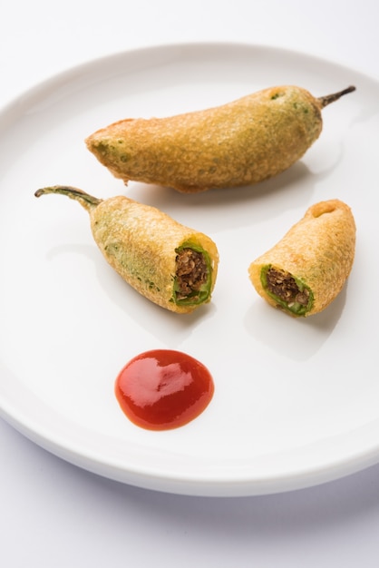 Crispy green chilli pakora or mirchi bajji, served with tomato ketchup. its a popular tea time snack from india especially in monsoon. selective focus