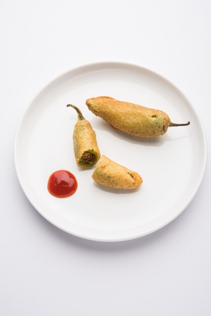 Crispy Green Chilli Pakora or Mirchi Bajji, served with tomato ketchup. Its a popular tea time snack from India especially in Monsoon. Selective focus