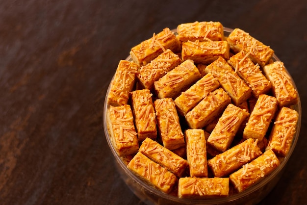 Foto crispy kastengel of kaasstengels koekjes in een pot op een donkere houten tafel