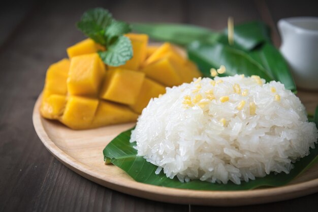 Crispy Mung bean on coconut milk and Flavored Sticky Rice with Ripe Mango on wood dish