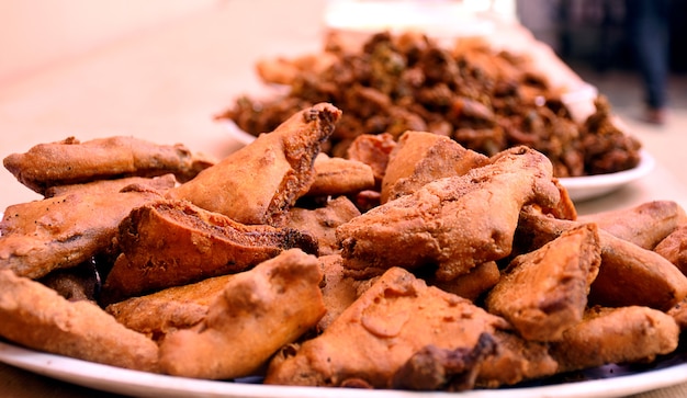 Crispy onion bhajis or kanda or pyaj ke pakore or pakoda , delicisous indian and brazilian street food on salad, typically enjoyed in rainy / monsoon season with hot tea, selective focus