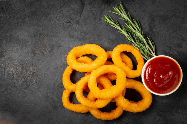 Photo crispy onion rings with ketchup.