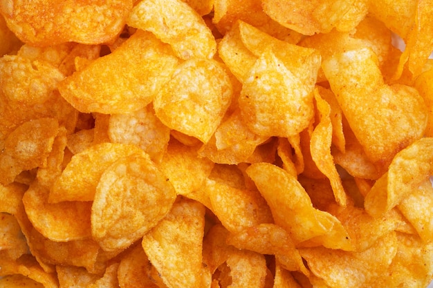 Crispy potato chips background texture of golden chips Fast food snack Close up