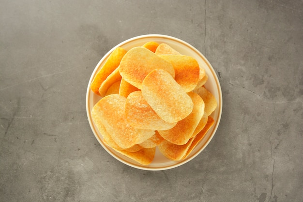 Crispy potato chips isolated over grey 