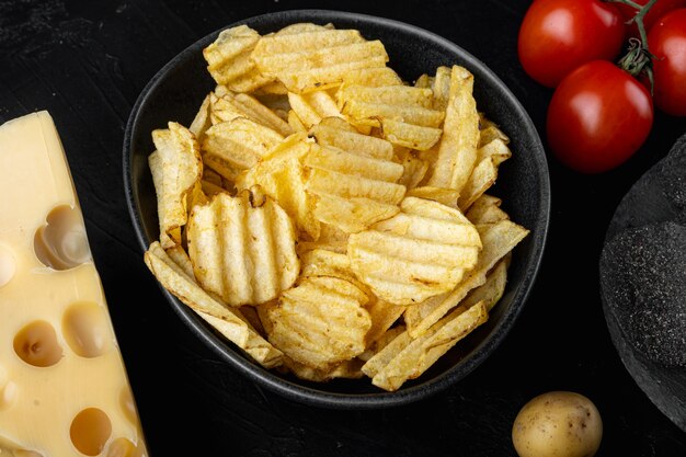 Crispy potato chips set, on black stone table