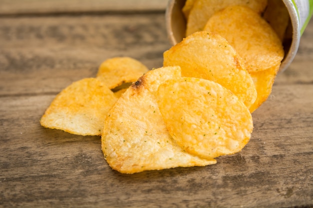 Crispy potato chips on wooden background