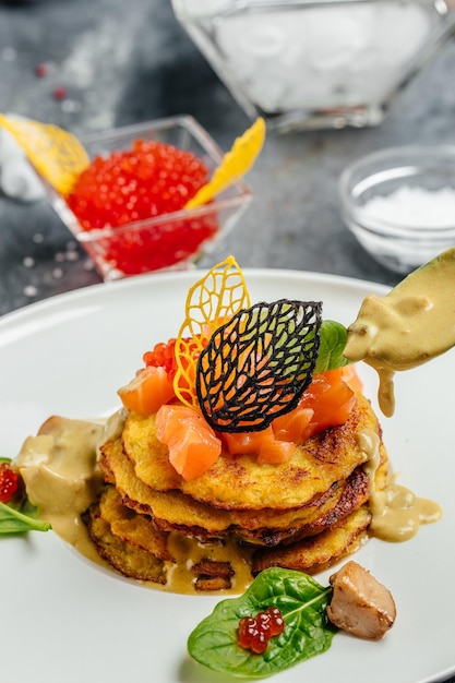 Crispy potato pancakes with red caviar, red fish and mushroom\
sauce. stack of potato pancakes fried. vertical image. top view.\
place for text.