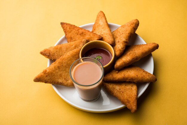 Crispy Potato triangles or batata vada covered with bread crumbs and then deep fried. served with tomato ketchup. selective focus