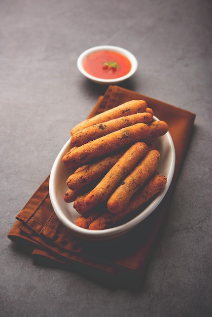 Crispy Rava Aloo fingers or Potato semolina fried finger sticks served with ketchup