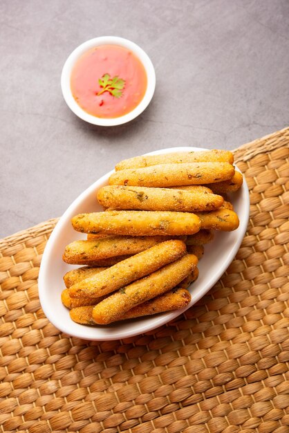 Crispy Rava Aloo fingers or Potato semolina fried finger sticks served with ketchup