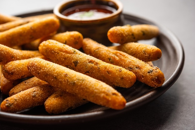 Crispy Rava Aloo fingers or Potato semolina fried finger sticks served with ketchup