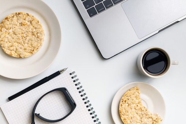 Crispy rice rounds with coffee near the laptop and notebook. 