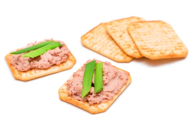 Crispy salted crackers with liver pate green onions and olives isolated