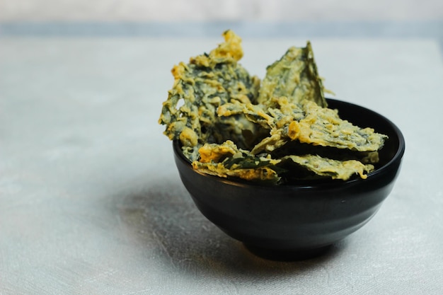 Foto chip di spinaci croccanti e salati fatti con foglie di spinace e farina di riso