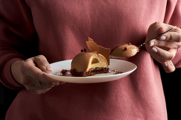 Foto crostata croccante con delicata mousse al cioccolato e caramello salato in women's hands