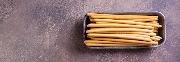 Crispy toasted sweet straws with berry jam in a container Top view Web banner