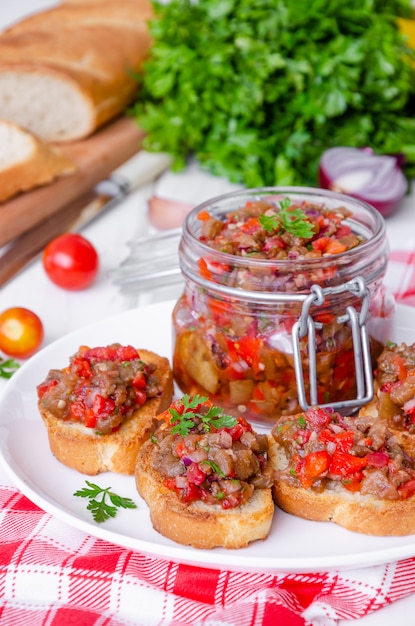 Crispy toasts with eggplant caviar on white plate