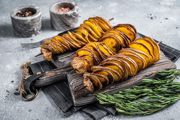 Crispy Tornado or twist potatoes chips on wooden board. Gray background. Top view.