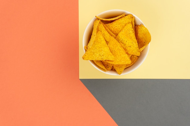 Crispy tortilla nachos corn chips in a white plate with a place for text obstraction.