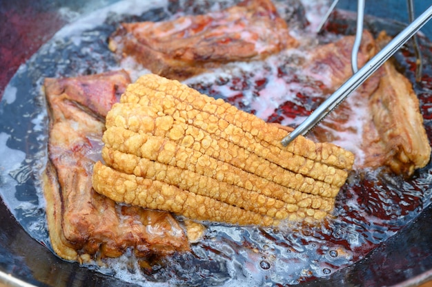 Crispy varkensvlees wordt gefrituurd op hoge hitte in een pan Het ziet er erg heerlijk uit