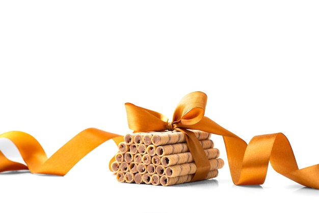 Crispy wafer rolls tied with a ribbon on a white background
