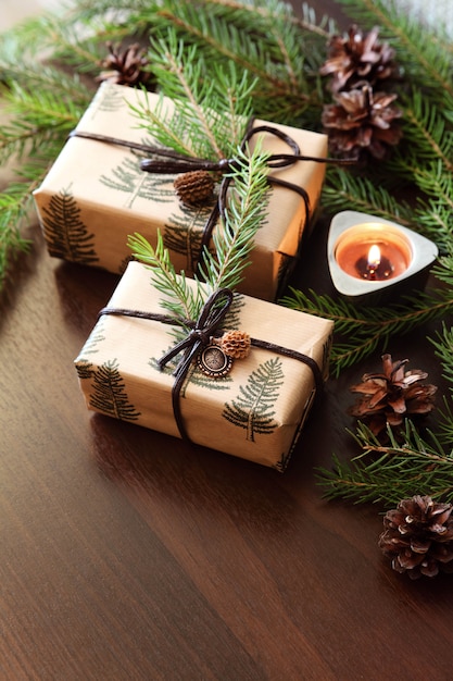 Cristmas presents. Burning candle and branches of a Christmas tree.