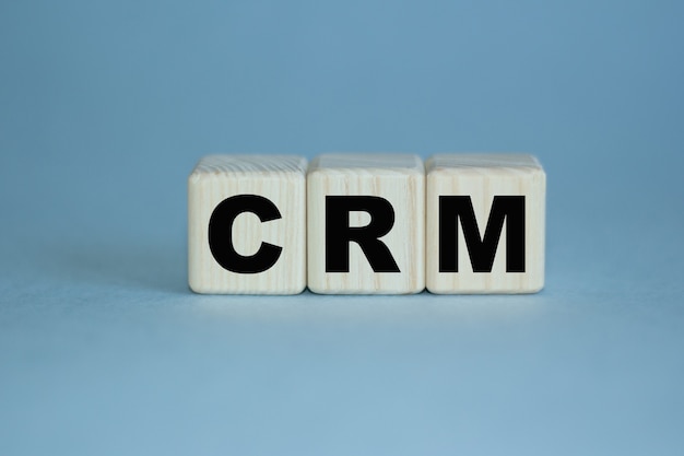CRMの単語は木製の立方体に書かれています。ビジネス、マーケティング、財務の概念に使用できます。セレクティブフォーカス。