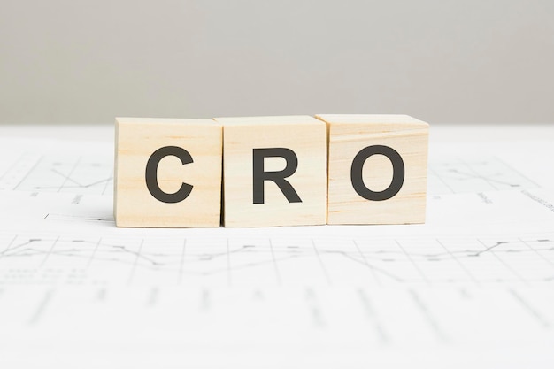 灰色の背景にCRO木製ブロックワード。 CRO-コンバージョン率の最適化、情報の概念の略。