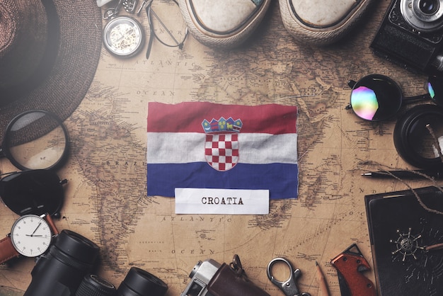 Флаг Хорватии между аксессуарами путешественника на старой винтажной карте. Верхний выстрел
