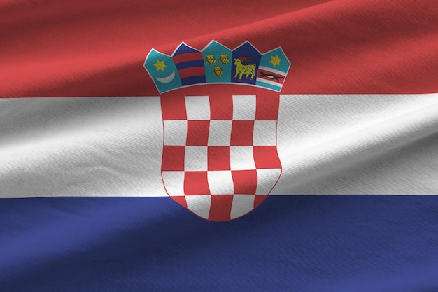 Croatia flag with big folds waving close up under the studio light indoors The official symbols and colors in banner