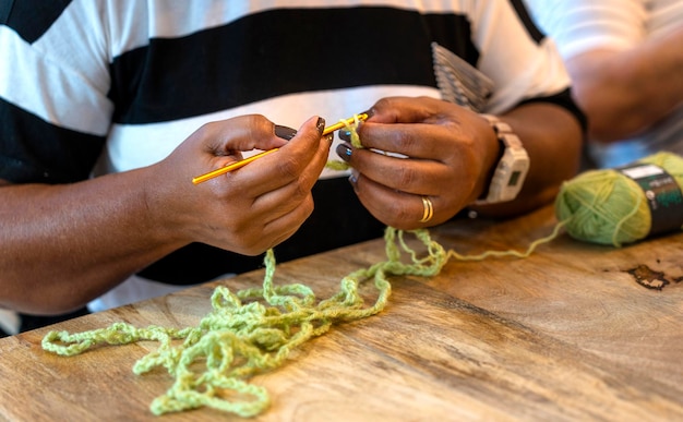 Crochet club Closeup of a black middleaged woman's hands knitting