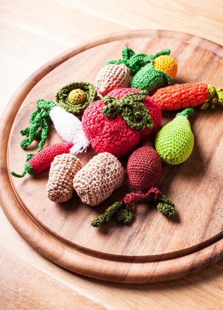 Photo crochet vegetables on a wooden board - eco toys or kitchen decor