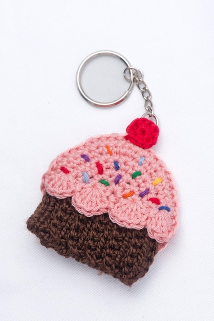Crocheted keychain in the shape of a vanilla and raspberry cupcake