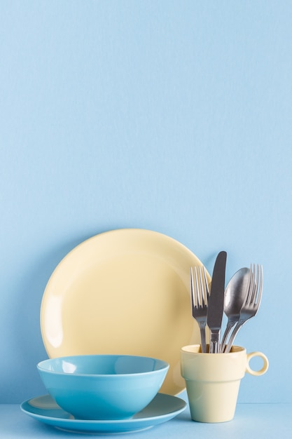 Crockery and cutlery on a blue pastel background