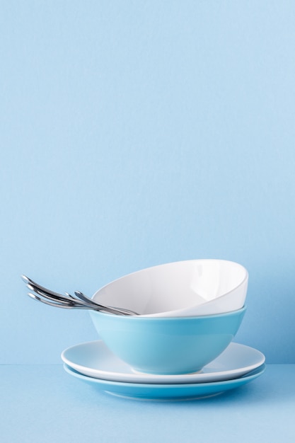 Crockery and cutlery on a blue pastel background