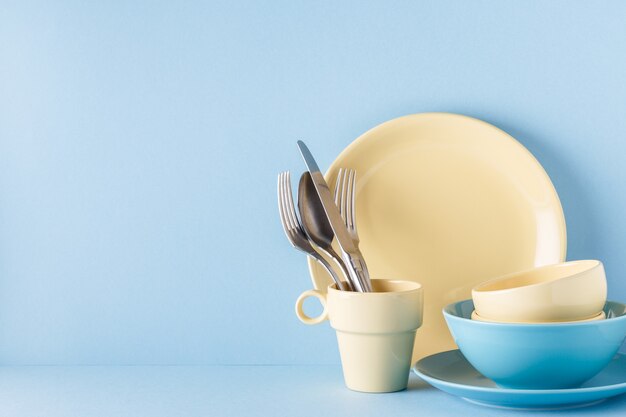 Crockery and cutlery on a blue pastel.