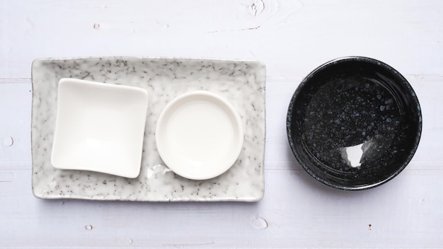 Crockery set with porcelain ceramic round dish cup bowl and
square plate isolated on white table