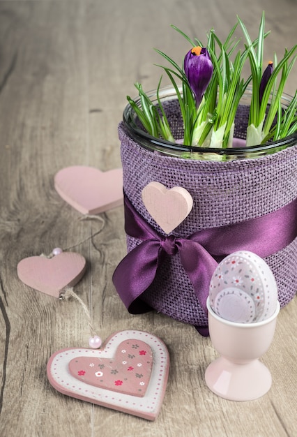 Crocus flower pot and pink Easter decorations on wood