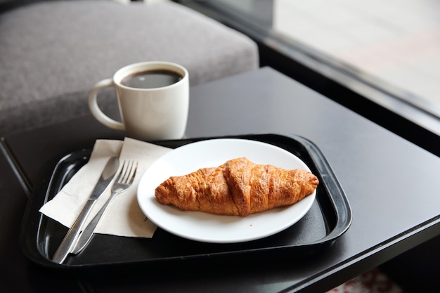 Croissant and coffee in coffee shop