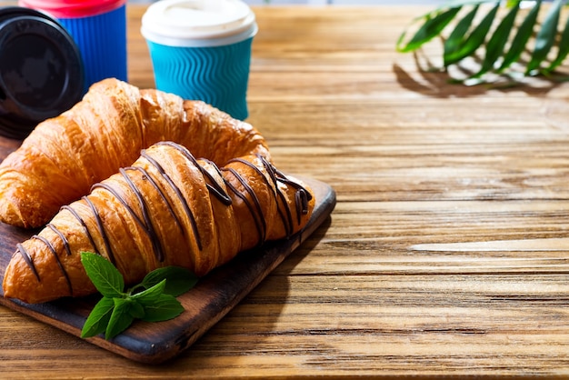 Croissant and coffee on wooden table